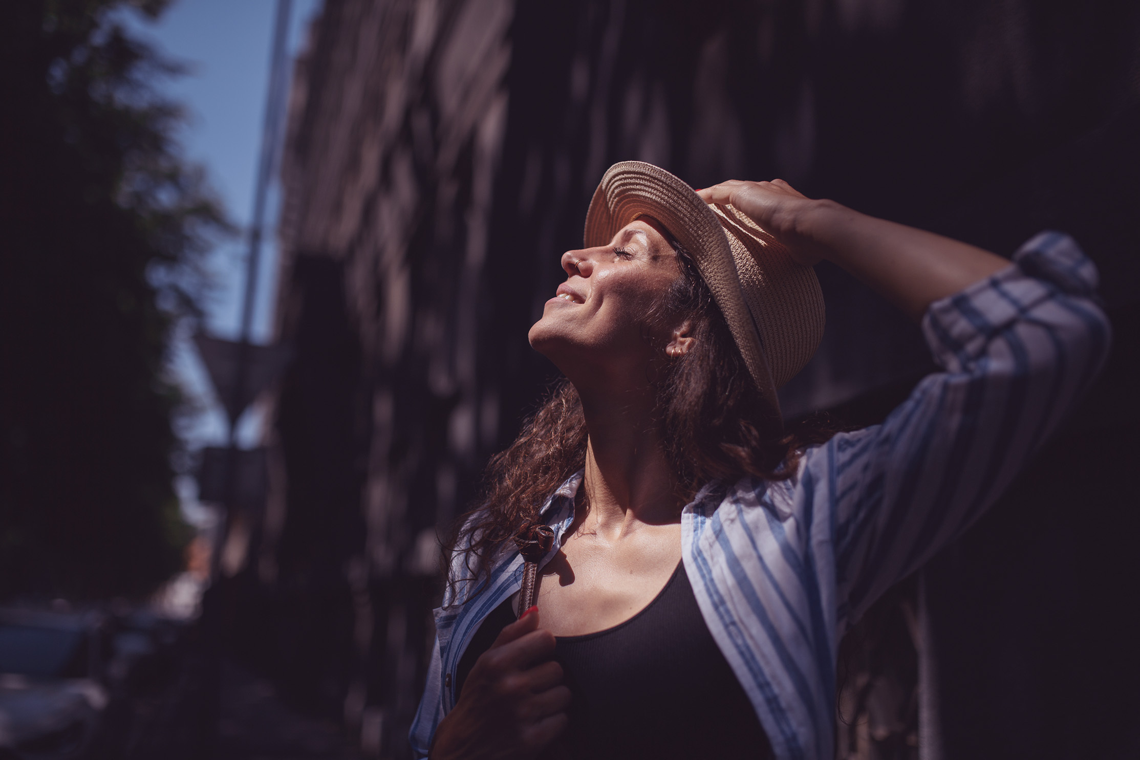 Woman outside looking up at the sun smiling