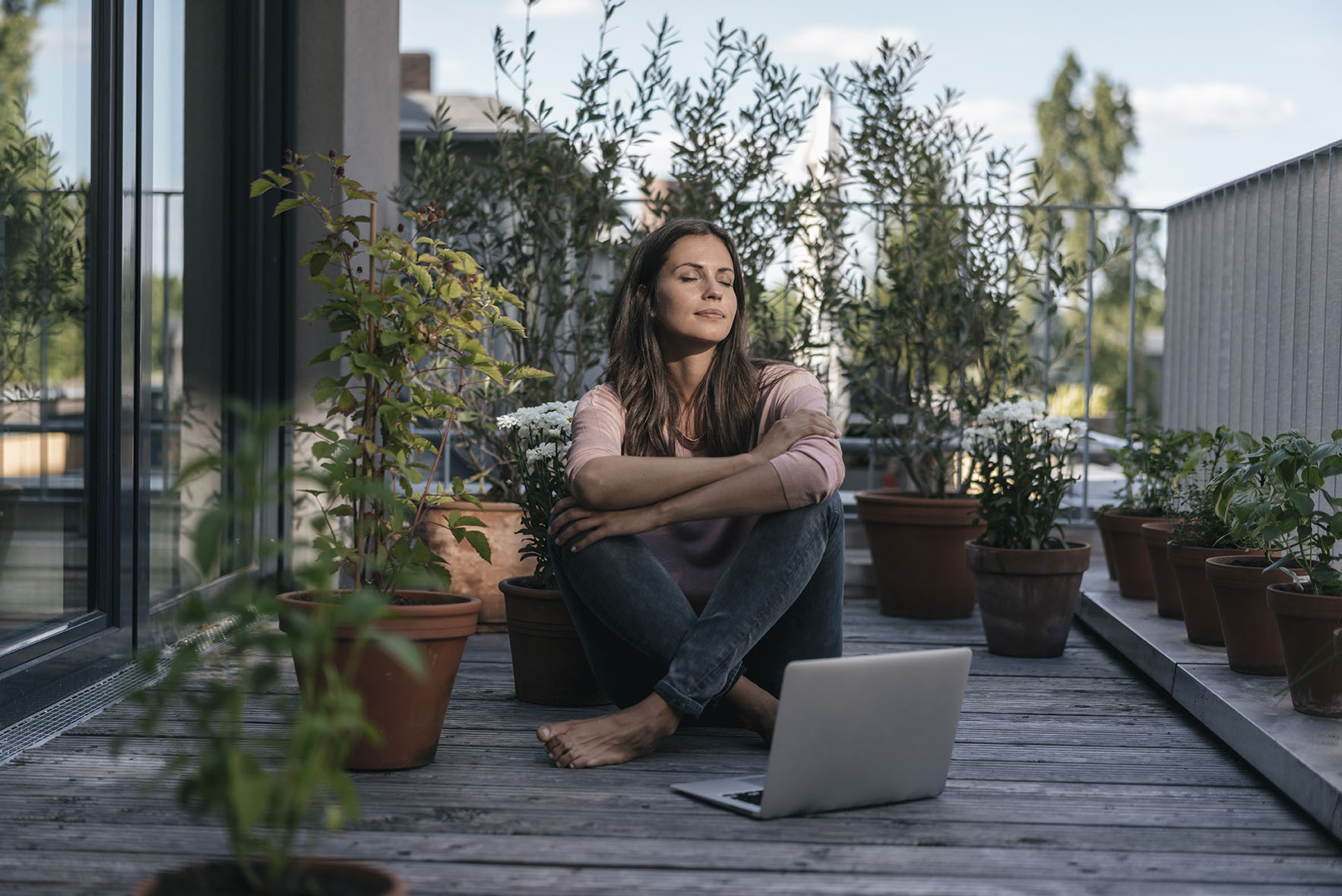 Woman sitting on her balcony outside enjoying pleasant weather