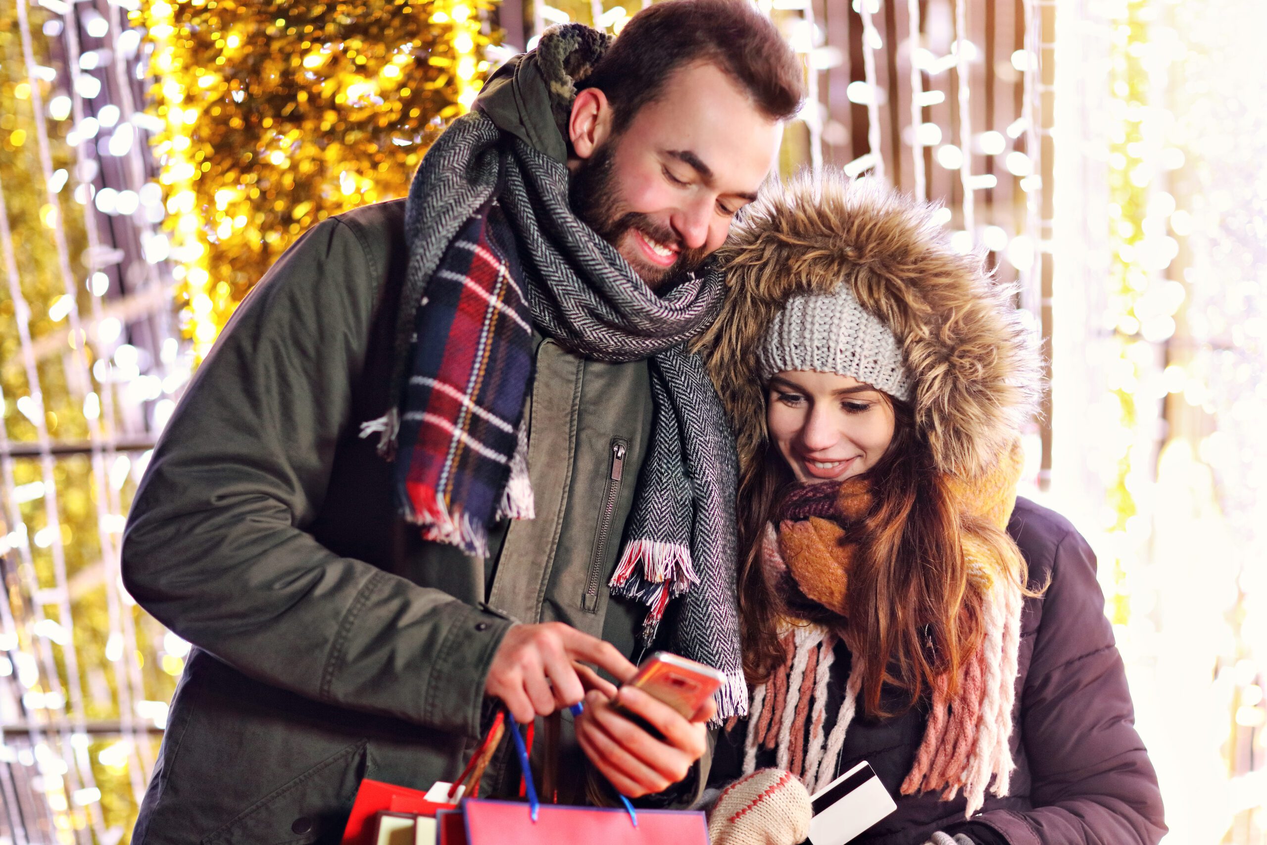 A man and woman couple shopping during the holidays