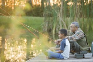 Grandfather and grandson fishing on pier